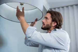 Man installing a bulb in living room