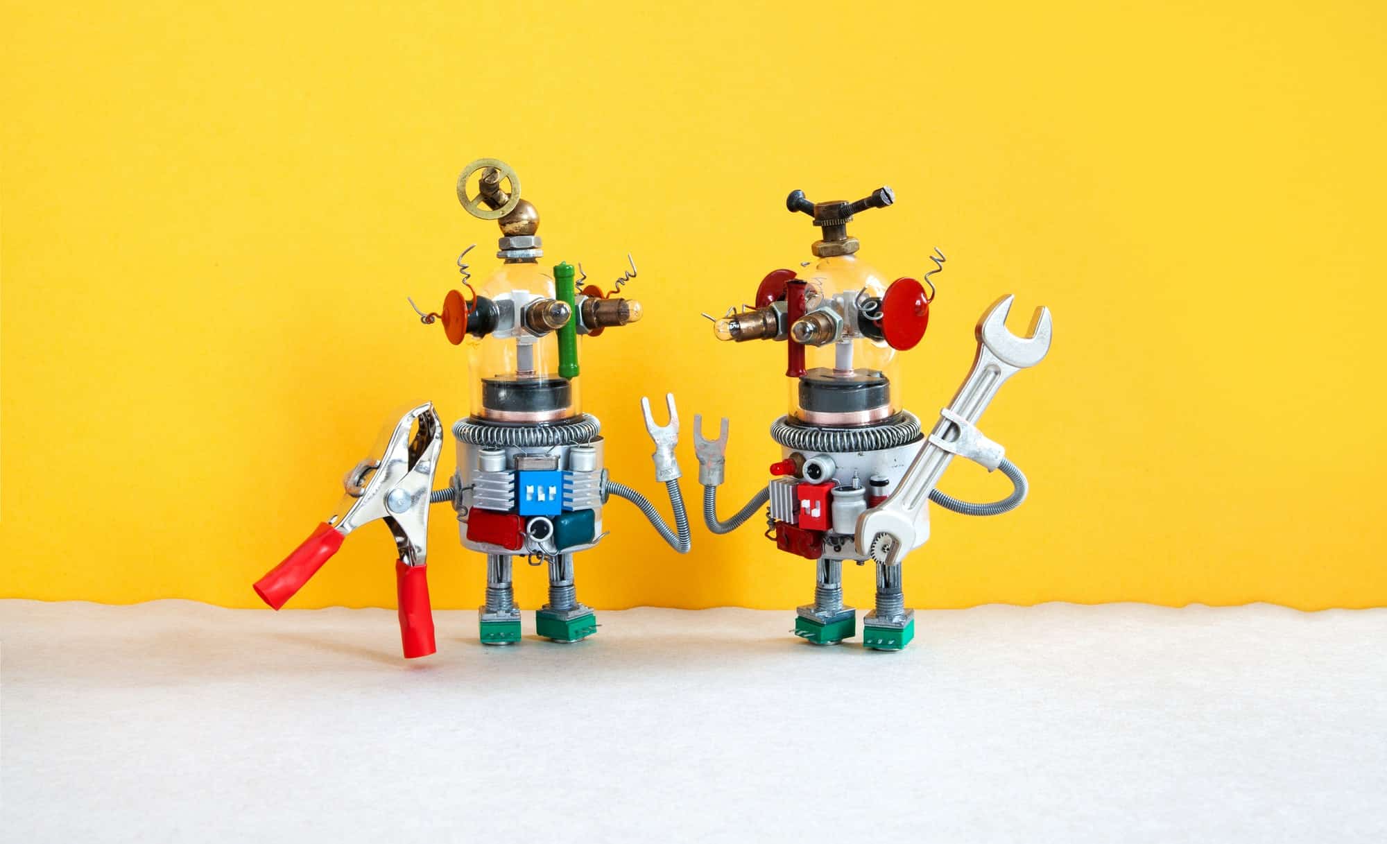 Two comical electrician robots are ready for maintenance.