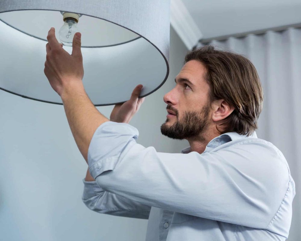 Man installing a bulb in living room
